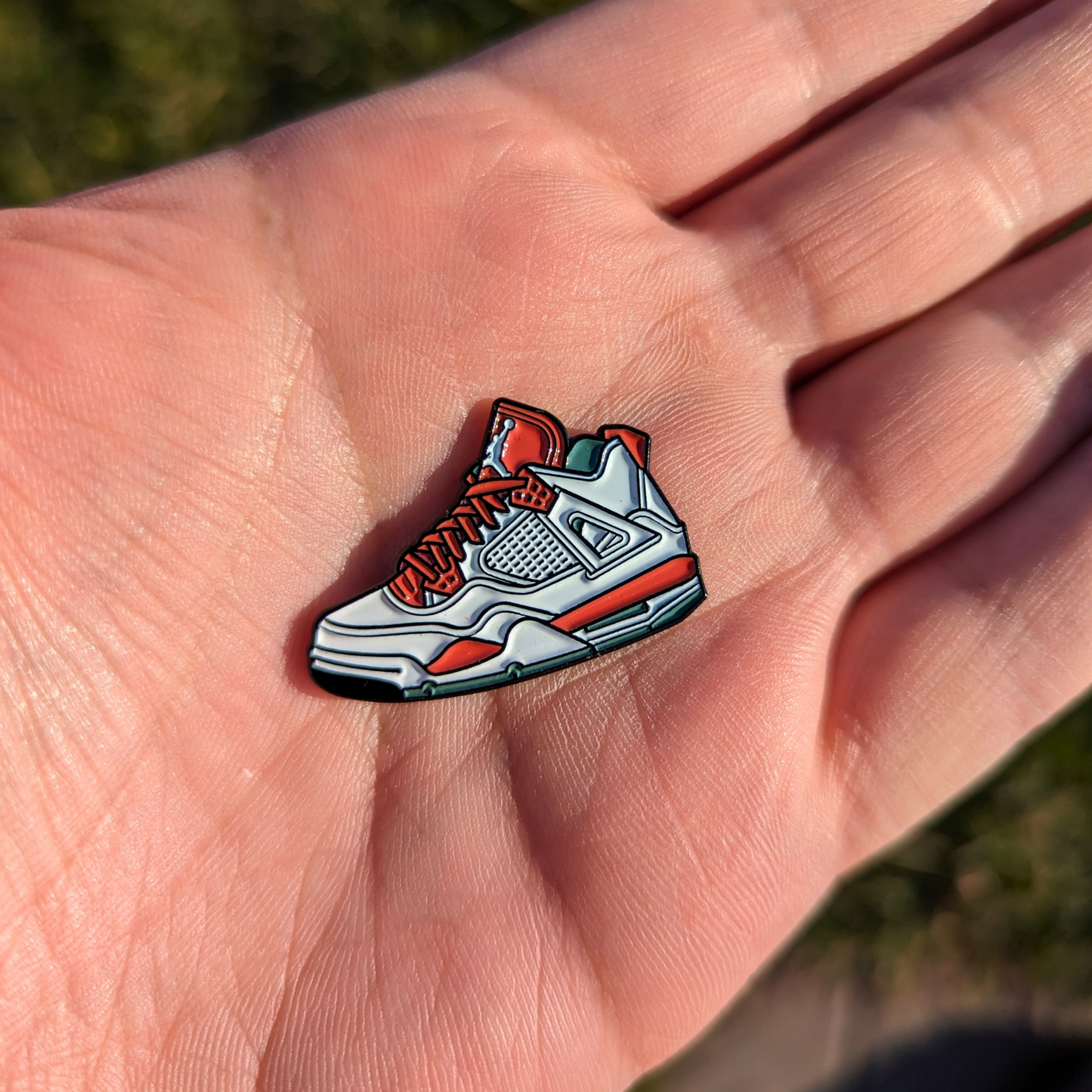 red and white jordans golf ball marker in hand