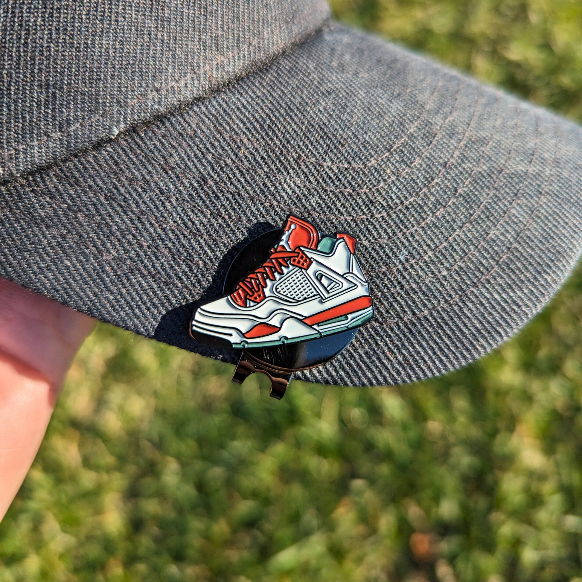 red and white jordans golf ball marker attached to hat with hat clip