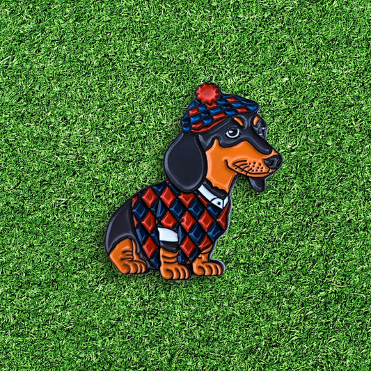 golf ball marker of daschund dog wearing a red and blue scottish golf outfit