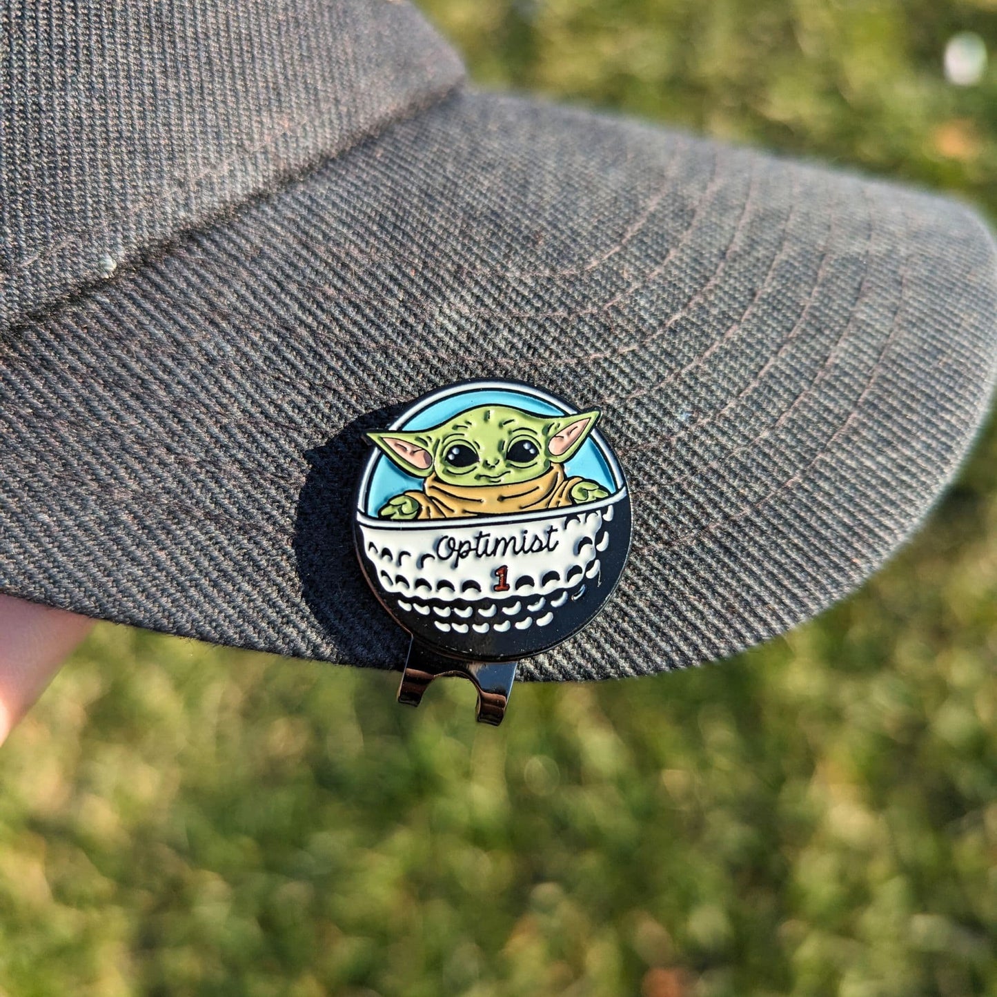 golf ball marker of green star baby in golf ball spaceship clipped on hat