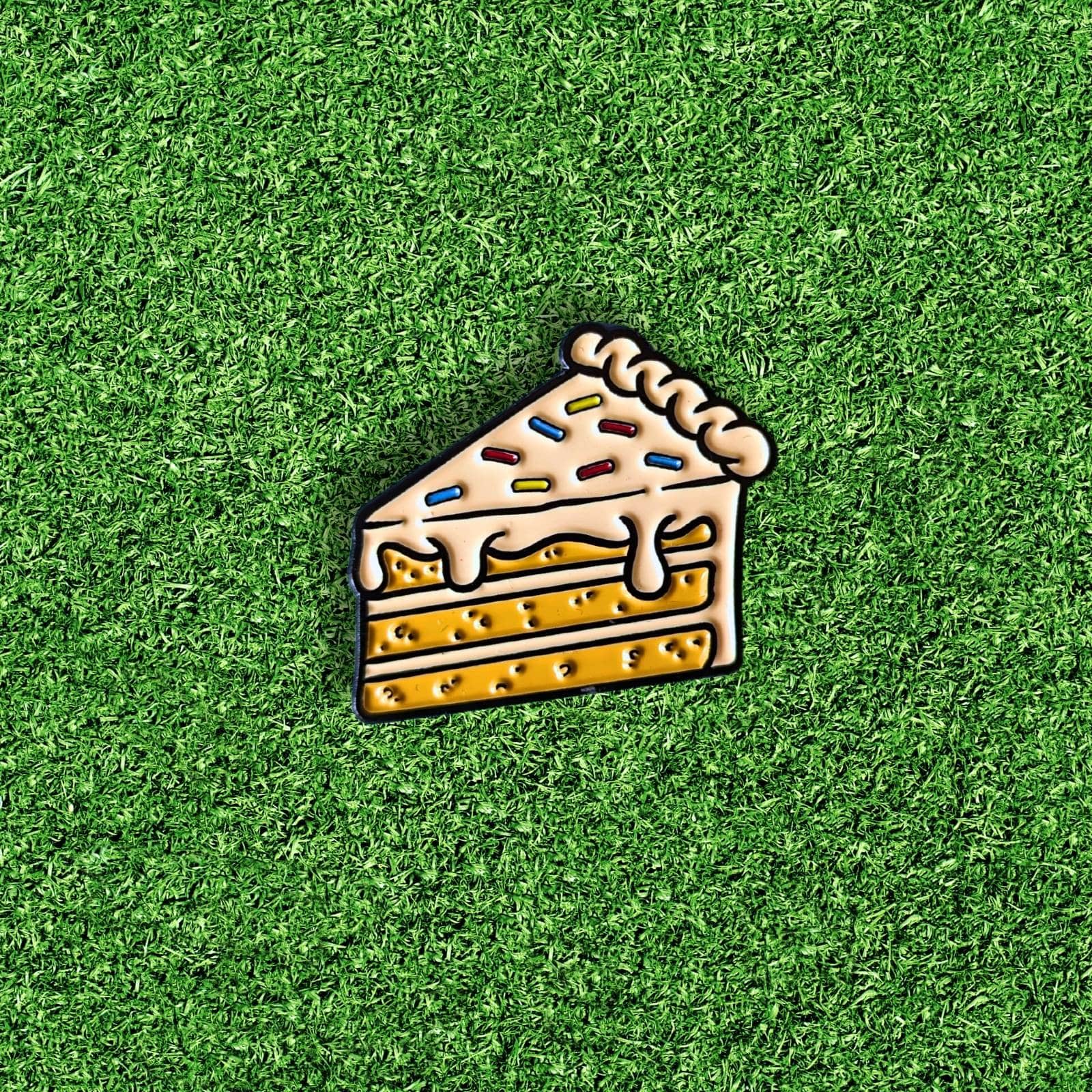 cake golf ball marker with white frosting and rainbow sprinkles