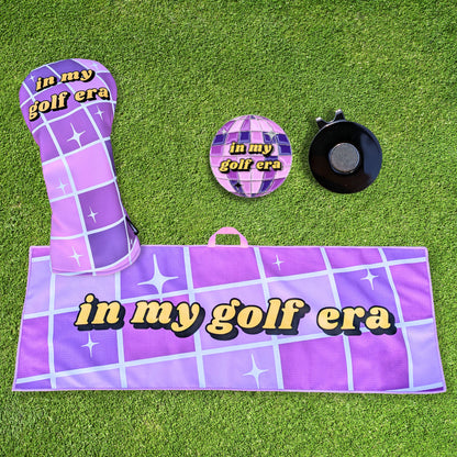 purple swiftie golf gift set that includes headcover, towel, and ballmarker with mirrorball design that says 'in my golf era'