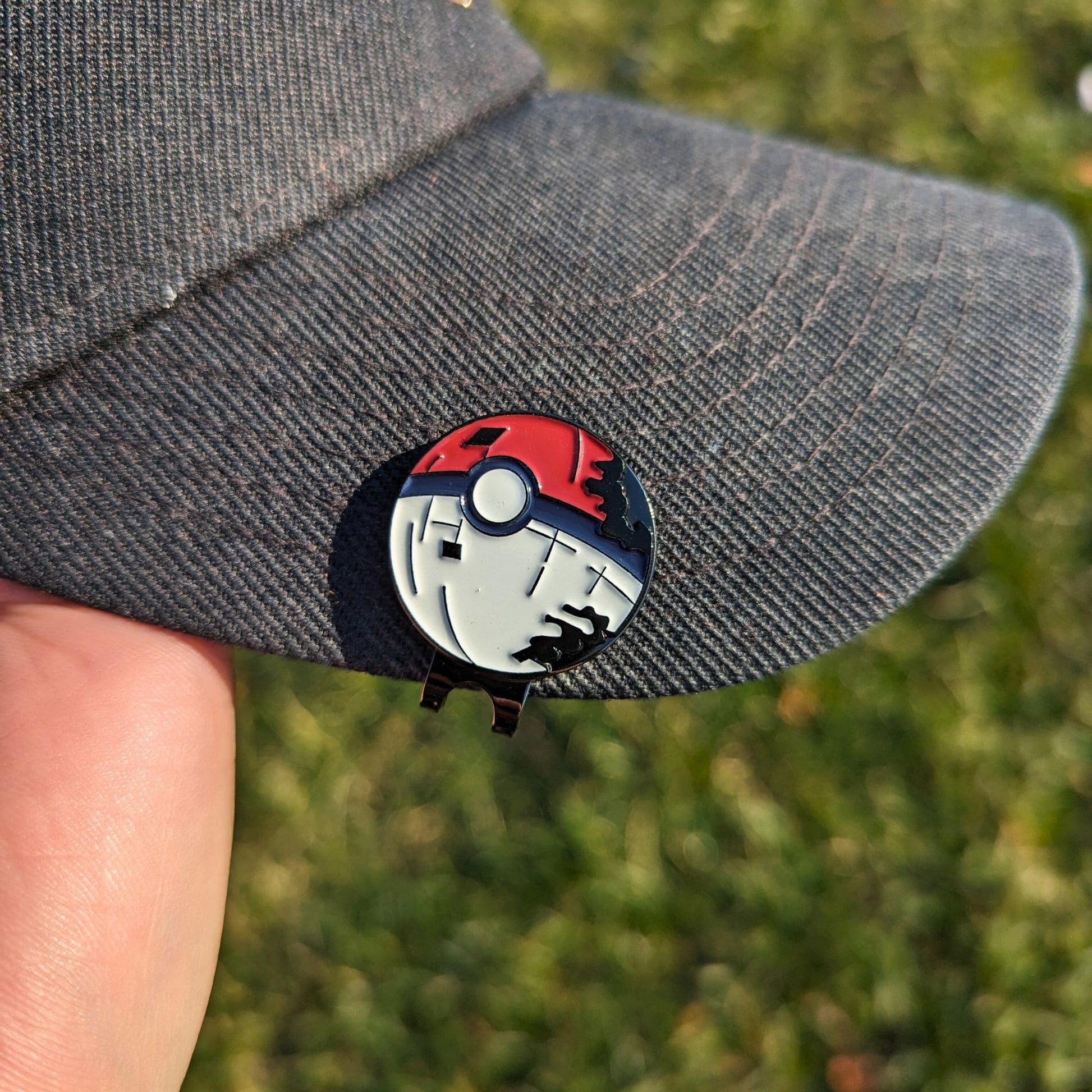 red and white poke star golf ball marker clipped on hat