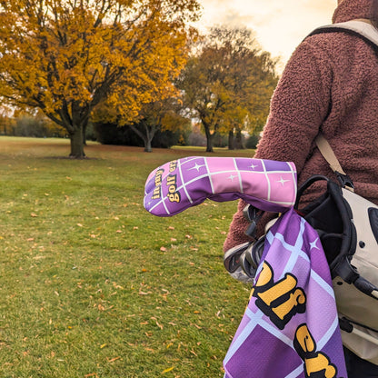 woman holding a golf bag with a purple headcover and towel that say 'in my golf era' with disco ball design