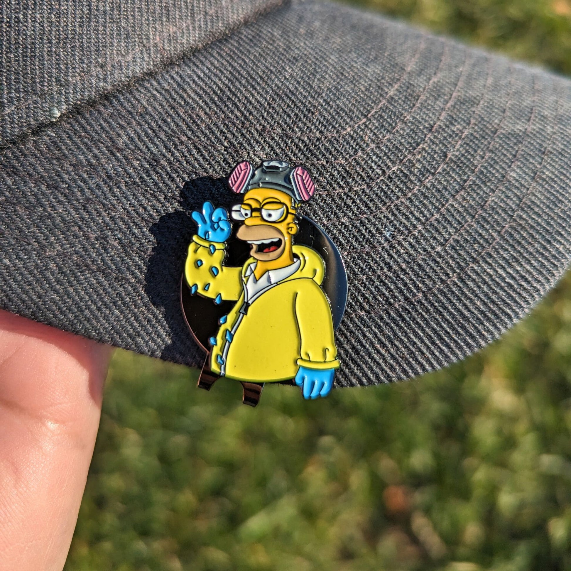 golf ball marker of yellow homerberg sprinkling salt clipped on hat