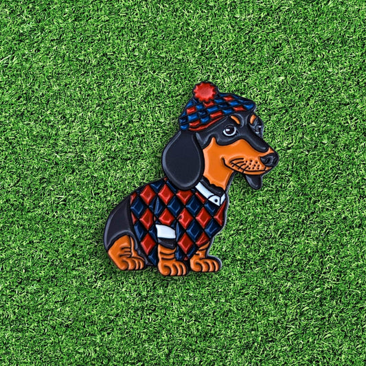 golf ball marker of daschund dog wearing a red and blue scottish golf outfit
