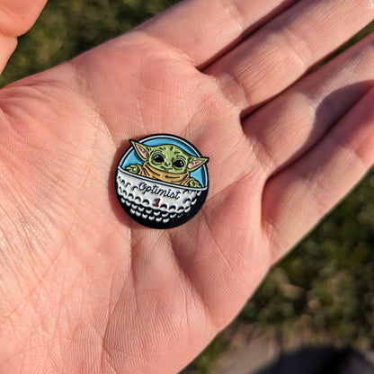 golf ball marker of green star baby in golf ball spaceship in hand